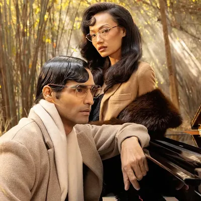 A campaign shot for John Jacobs Eyewear's "Winter Edit," featuring two models in a romantic, vintage-inspired setting we created with a piano and atmospheric fog.