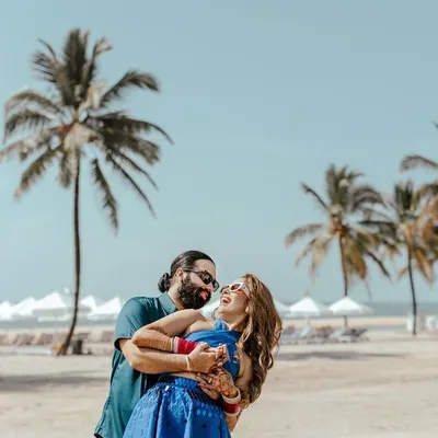 A moment of pure laughter and joy between the couple on a sunny Goa beach, the perfect candid shot from a pre-wedding celebration.