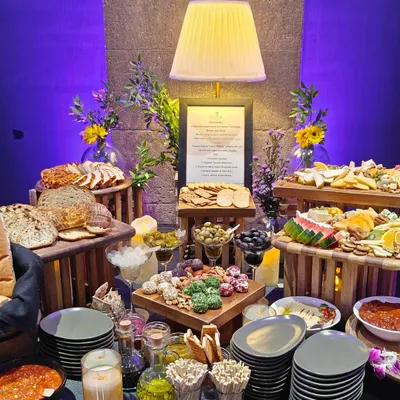 A stunning tapas grazing table created for a Mercedes-Benz tequila soirée. This abundant display features a wide variety of cheeses, breads, fruits, nuts, and dips, serving as a visual and culinary focal point.