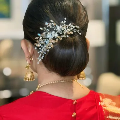 A bun kissed by grace. This sleek and elegant updo is adorned with a beautiful hair accessory, perfect for a wedding or formal event.