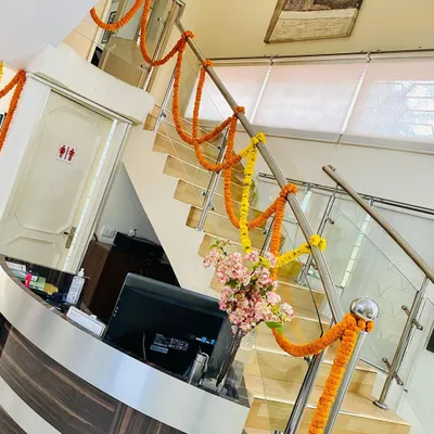 This is how I bring a festive feel to office interiors. By wrapping the staircase railing in an office reception area with simple marigold garlands, the entire common space feels brighter and more welcoming for staff and visitors.