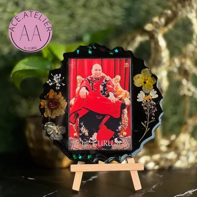 A beautiful resin frame of Guruji, adorned with real dried flowers against a classic black background. This piece is designed to bring blessings and serenity to your home.