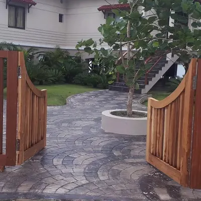 The entrance to your home should be welcoming. I designed this entryway with a custom wooden gate that opens onto a gracefully curved stone path, leading visitors through a lushly planted garden.