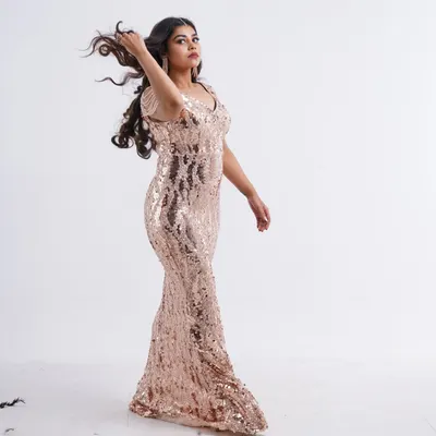 Feel the glamour in this stunning rose gold sequin gown. The way it catches the light is perfect for a fashion shoot, and the movement in the hair adds a dynamic touch.