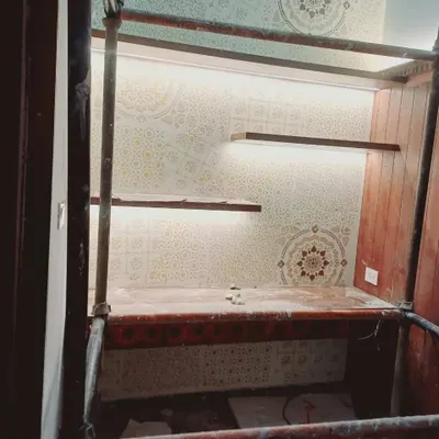 This custom-stenciled study nook features a complex geometric and mandala pattern. The design is integrated with built-in shelving and accent lighting, demonstrating how our work can be tailored to fit specific architectural features.