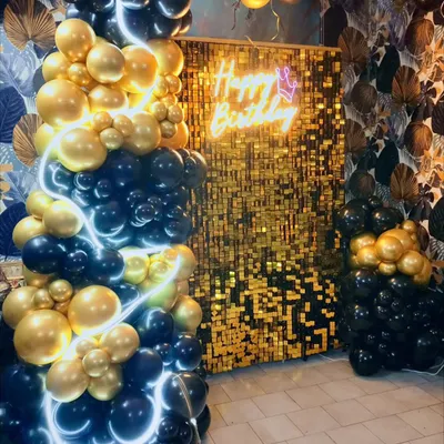 Glamour and sophistication for a memorable birthday. This stunning setup features a cascade of black and gold balloons, a glittering gold sequin backdrop, and a 'Happy Birthday' neon sign for a truly luxurious feel.