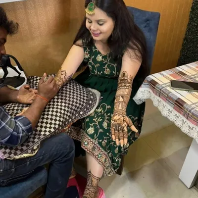Here I am applying bridal mehandi for a client at her home. You can see her showing off the finished design on one hand while I work on the other.