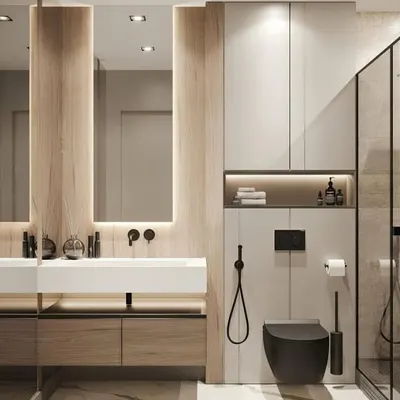 A sleek, modern bathroom with a floating wooden vanity, a minimalist white sink, and built-in storage. The combination of light wood, white surfaces, and black fixtures creates a clean and contemporary look.