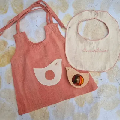I've always been a sucker for creative collaborations. This newborn gift set is a partnership with Sankalpa Art Village, featuring a naturally dyed kora cotton dress, a bib, and our own Channapatna bird rattle.