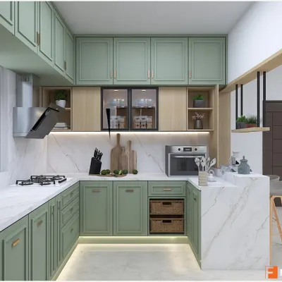 A beautiful U-shaped kitchen in a soft mint green, featuring classic shaker-style cabinets and a white marble-effect countertop. The design includes a breakfast counter and open shelving for a light, airy feel.
