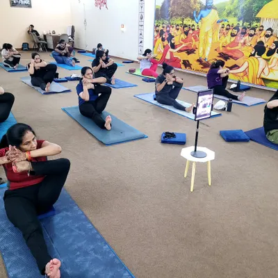 A moment of focused stretching in our group class. This seated twisting pose, Marichyasana, is excellent for improving spinal flexibility and aiding digestion. Notice how some students are also connected to our live online session.