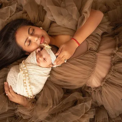 A truly angelic portrait of a mother and her newborn. Lying amidst a sea of soft brown fabric, this shot is all about peace, love, and that incredible bond.