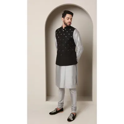 The 'Shoorveer' set is my modern interpretation of a classic. I've paired a black Bandi jacket, detailed with minimal silver embroidery, with a shimmering grey-silver kurta and churidar for a look that is both understated and sophisticated.