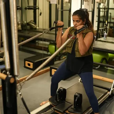Indian cricketer Harmanpreet Kaur works on the reformer and chair, demonstrating exercises that build unilateral strength and stability. This is crucial for athletes to correct muscle imbalances and prevent injuries.