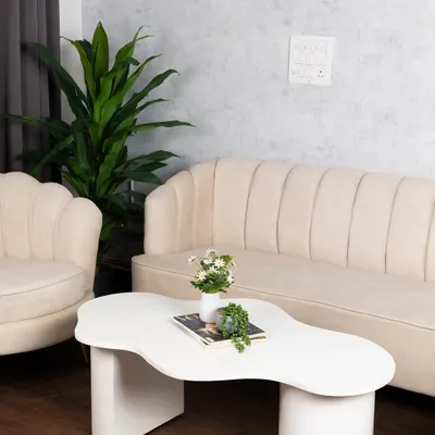 This wider view shows our main lounge set, featuring the fluted sofa and armchair against the textured grey wall. It’s a perfect setup for interviews, portraits, or lifestyle brand shoots.