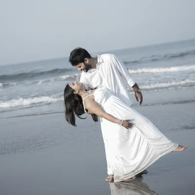 A classic romantic dip pose on a Goan beach, with the waves washing over their feet, creating a timeless and cinematic pre-wedding photo.