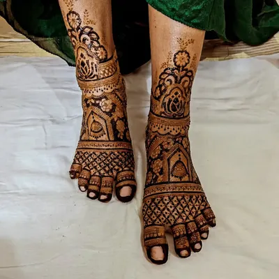 A breathtaking full-coverage foot mehendi design. The intricate patterns and dark stain create a stunning look, perfect for a bride.