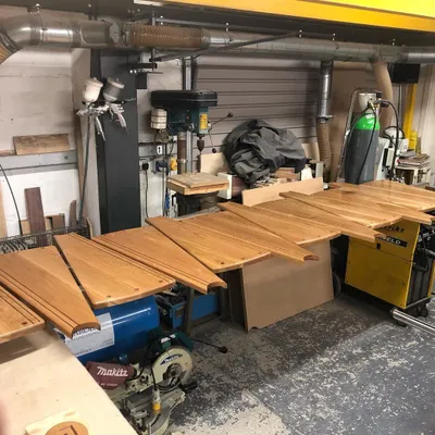 Solid oak treads for a spiral staircase, shaped and finished in the workshop. They are laid out here for a final quality check before being packed for site delivery.