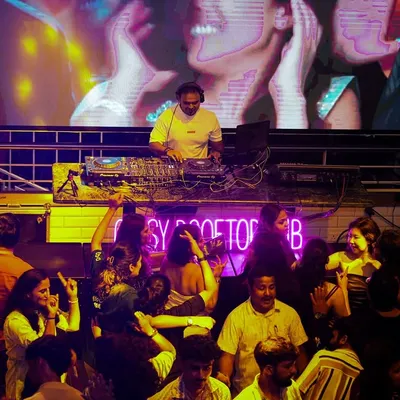A wide shot from my console at Gypsy Tower Rooftop. You can see how the large LED screen behind me becomes part of the show, with visuals that match the energy of the Bollywood tracks I'm playing for the packed dancefloor.