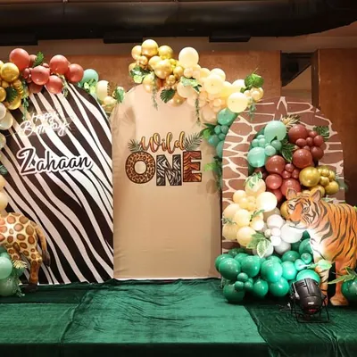 Let the wild rumpus start! This "Wild One" first birthday party features a stunning jungle theme with animal print backdrops, life-sized giraffe and tiger props, and lush green flooring.