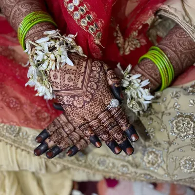 This is the stain goal for every bride. A close-up of the rich, dark color on the hands, adorned with fresh flowers and a beautiful ring. This is the result of my organic henna.