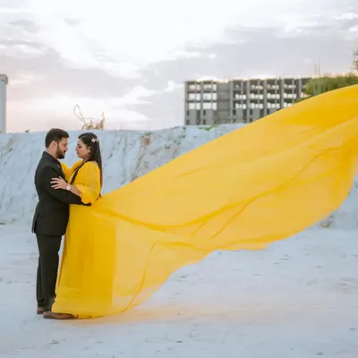 The vibrant yellow of this flying gown creates a stunning pop of color against the white landscape. I love creating these high-contrast, dramatic images that feel both artistic and romantic.