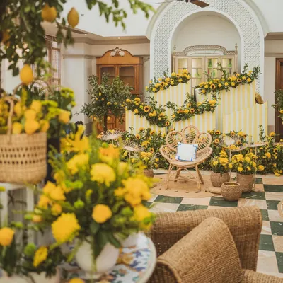 A vibrant and sunny Haldi setup, featuring a beautiful seating area surrounded by fresh sunflowers, lemon trees, and cheerful yellow decor.