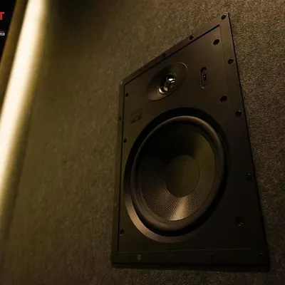 A close-up of an OSD Black T83 in-wall speaker, seamlessly integrated into the acoustic paneling of a luxury home cinema in Chennai.