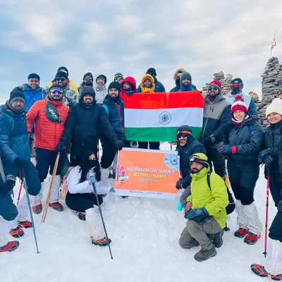 Summit day success. Our first Kedarkantha batch from Bengaluru celebrating their achievement at the top, surrounded by a sea of snow and mountains.