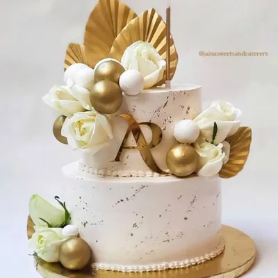 Celebrating one year of togetherness with this stunning two-tier anniversary cake. The design features a white marble effect, gold accents, and fresh white roses for a look of pure elegance.