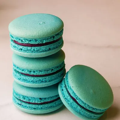 A stack of our beautiful turquoise macarons. Each one has a crisp shell, a chewy center, and is filled with a delicious ganache.