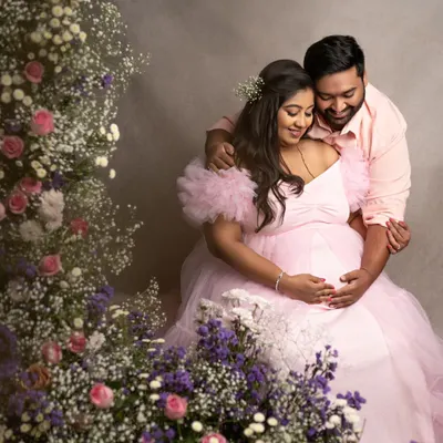 A fairytale moment for this beautiful couple. The mom-to-be in a flowing pink gown, surrounded by a garden of flowers, creates a truly magical and romantic portrait.