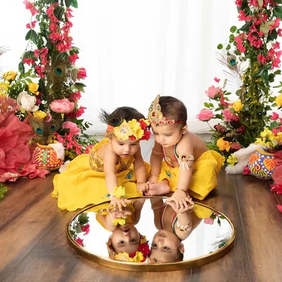 Double the divinity, double the fun. These two little ones, dressed as Radha and Krishna, share a moment of reflection in this beautifully styled Janmashtami setup.