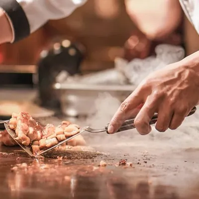 Our chef creating a spectacular display at a live Teppanyaki station. This Japanese style of cooking on an iron griddle is a performance in itself, providing both delicious food and entertainment for wedding guests.