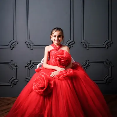 This little princess looks absolutely stunning in a magnificent red rose gown. Posed against our classic dark grey wall, she has the perfect royal persona for her birthday photoshoot.