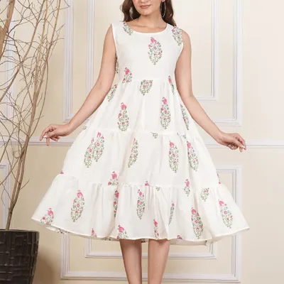 A beautiful white tiered cotton dress with delicate pink and green floral block prints. This sleeveless design is perfect for warm weather, offering a light and airy feel.