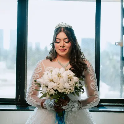 A serene portrait of the bride holding her bouquet just before the ceremony. I focus on capturing these quiet moments of anticipation and the beautiful details of the bridal look.