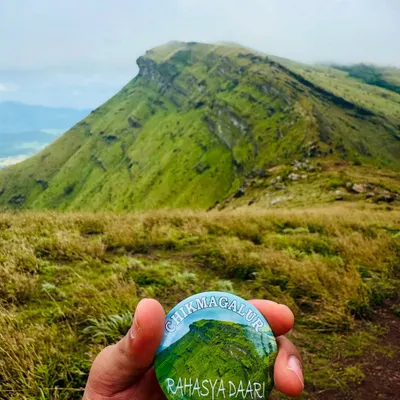 Our "Chikmagalur" badge held against one of the region's iconic peaks. A great souvenir from an amazing trip.