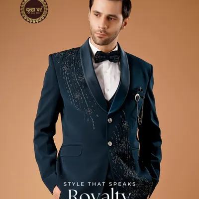 Style that speaks royalty. This deep teal tuxedo is designed for the modern groom's reception. The embellished lapel and sharp tailoring create a look that is both sophisticated and statement-making.