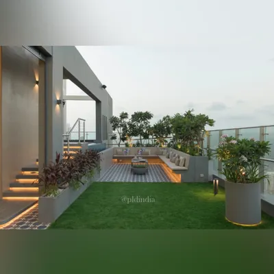 This rooftop terrace in Mumbai is a slice of heaven on earth. We combined a soft lawn with patterned tile flooring and built-in seating, creating a multi-functional space for relaxing and entertaining, all framed by lush planters.