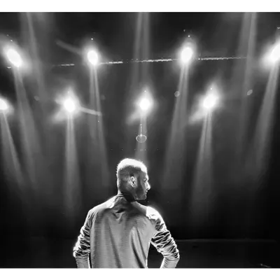 A high contrast, black and white shot of me on a stage, backlit by powerful spotlights. This frame is all about drama, mood, and the power of lighting in cinematography.