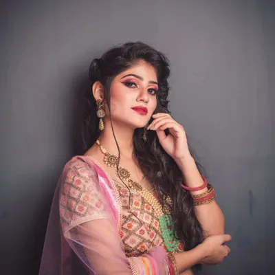 A fashion portrait with a confident attitude. I used a simple grey background and soft lighting to put all the focus on the model's expressive look, her vibrant makeup, and the intricate details of her pastel lehenga.