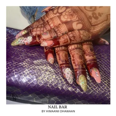 The ultimate bridal nail set. This design features a mix of glitter, lattice patterns, and delicate accents that look stunning against dark mehendi.