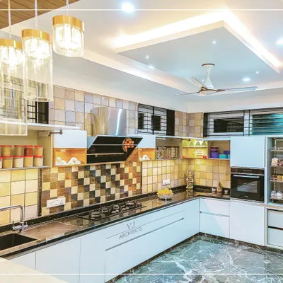 This modern L-shaped kitchen features a striking checkerboard tile backsplash and sleek white handleless cabinets. The overhead lighting and under-cabinet LEDs ensure the workspace is always well-lit.
