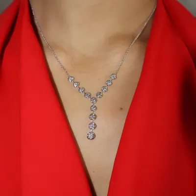 Let the neckline do the talking. This delicate Y-shaped diamond necklace features a cascade of round brilliant diamonds, designed to elongate the neck and add a touch of modern elegance.