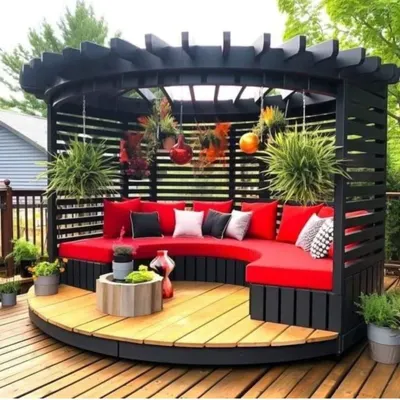 This circular pergola with built-in curved seating is a perfect example of our custom design capabilities. The vibrant red cushions add a pop of color to the dark wood structure, creating a stunning focal point.