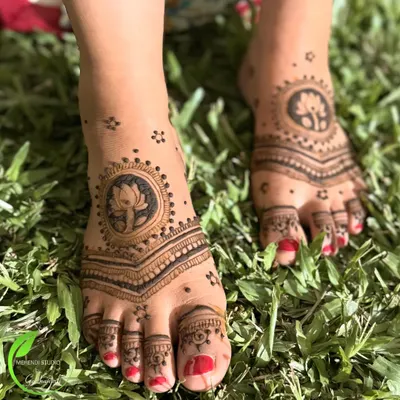 A simple and elegant foot mehendi design. This pattern features a central lotus motif with delicate lines extending to the toes, perfect for any occasion.
