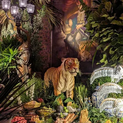 The decor for the Sabyasachi 25th anniversary was all about opulence and grandeur. This shot shows how we integrated lush greenery around the event's props, like this tiger statue and ornate lamps, to create a scene that felt like a royal jungle.
