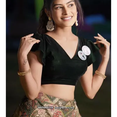A close-up of a simple yet elegant black velvet blouse with flutter sleeves, paired with a modern printed lehenga skirt.