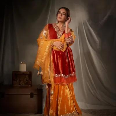 This look captures pure festive opulence. I chose a rich, jewel-toned velvet sharara set in shades of orange and red, accessorized with regal gold jewelry to create a look that is both traditional and incredibly glamorous.